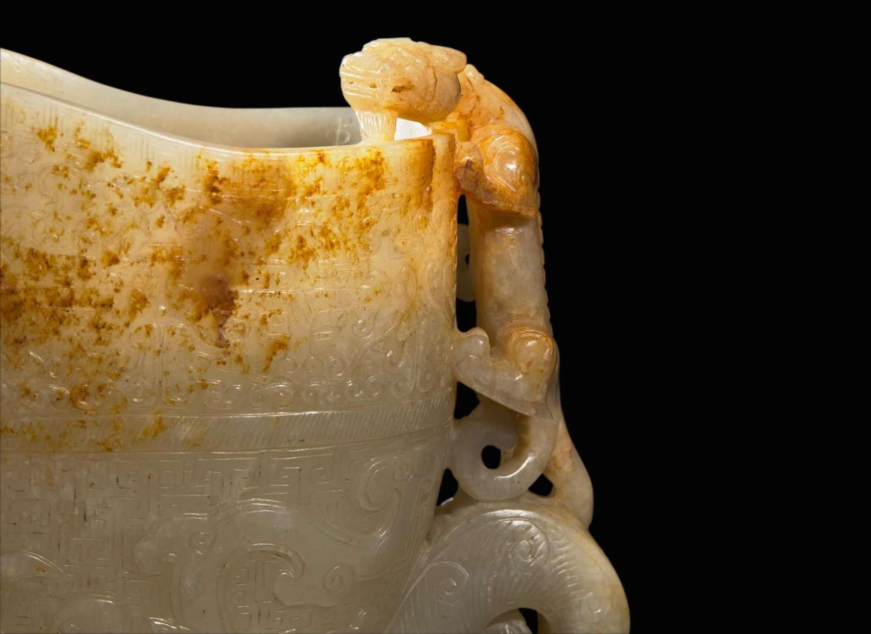 A large Chinese carved pale celadon and russet jade rhyton vessel 青白玉雕觥杯