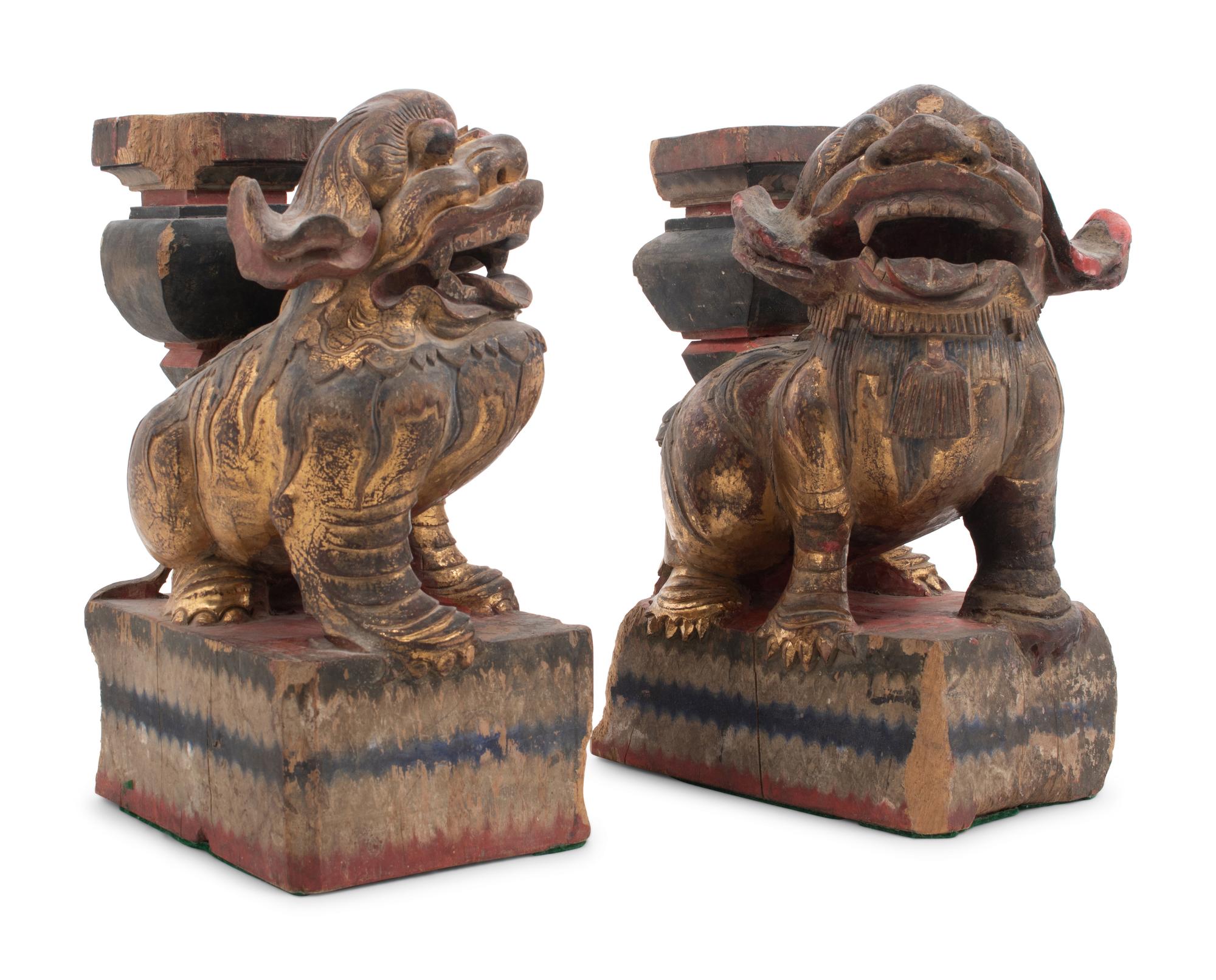 A Pair of Chinese Giltwood Candlesticks with Buddhistic Lions