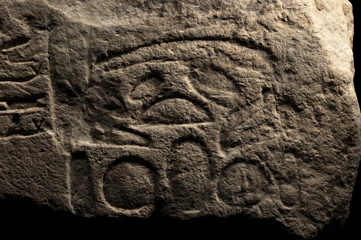 An Egyptian Limestone Relief Fragment Depicting an Attendant Wearing a Head-Cone