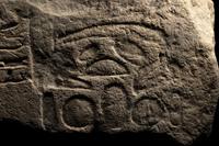 An Egyptian Limestone Relief Fragment Depicting an Attendant Wearing a Head-Cone