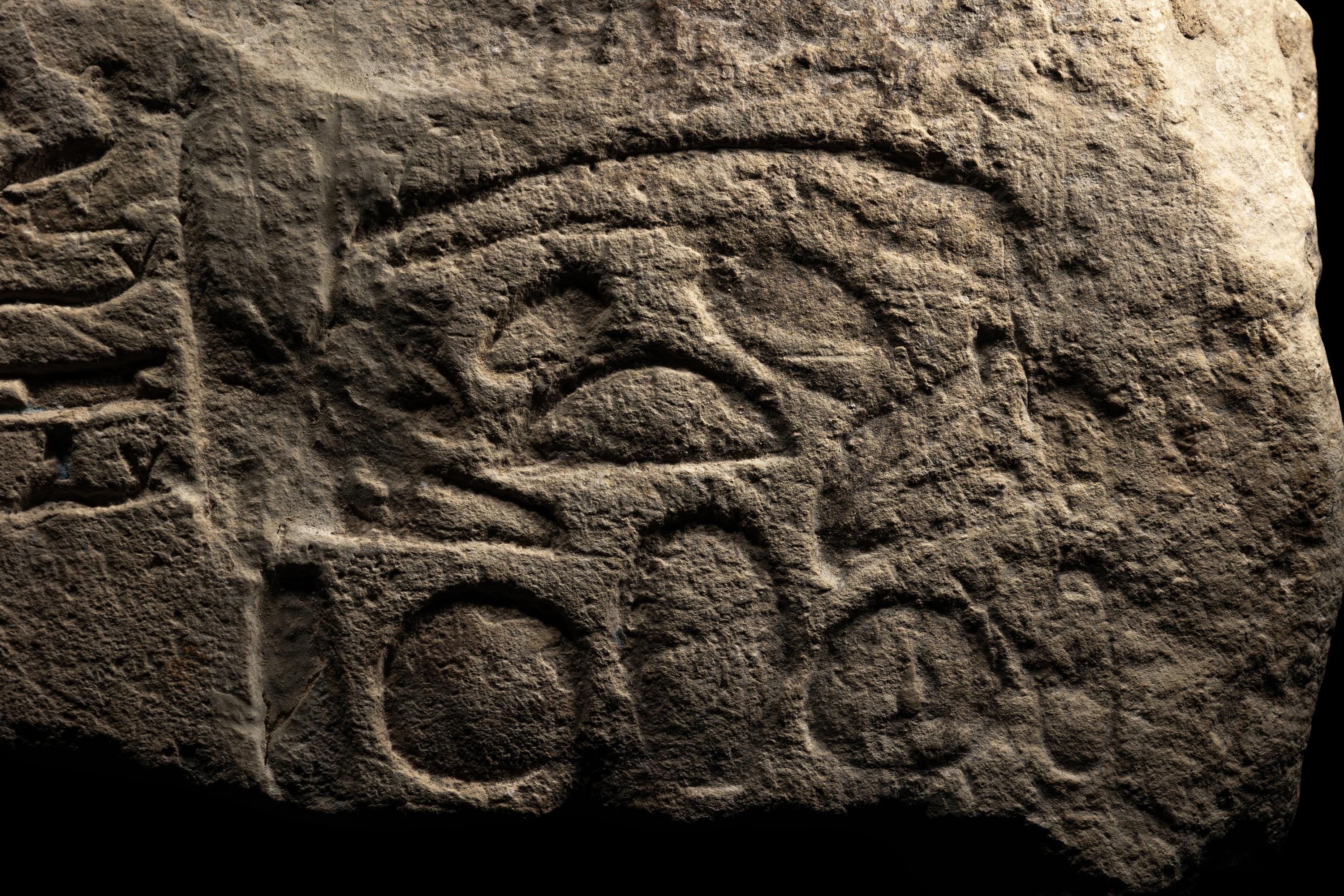 An Egyptian Limestone Relief Fragment Depicting an Attendant Wearing a Head-Cone