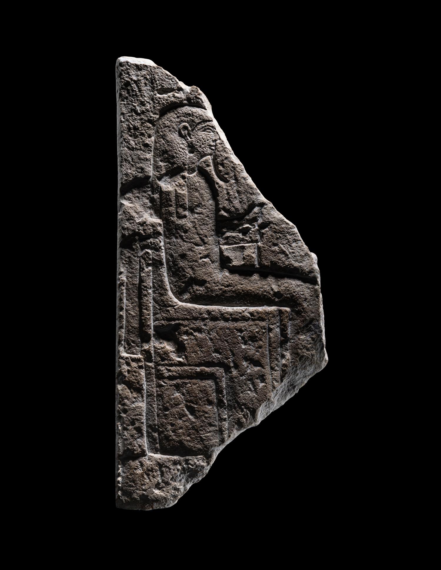 An Egyptian Limestone Stele Fragment with a Seated Pharaoh