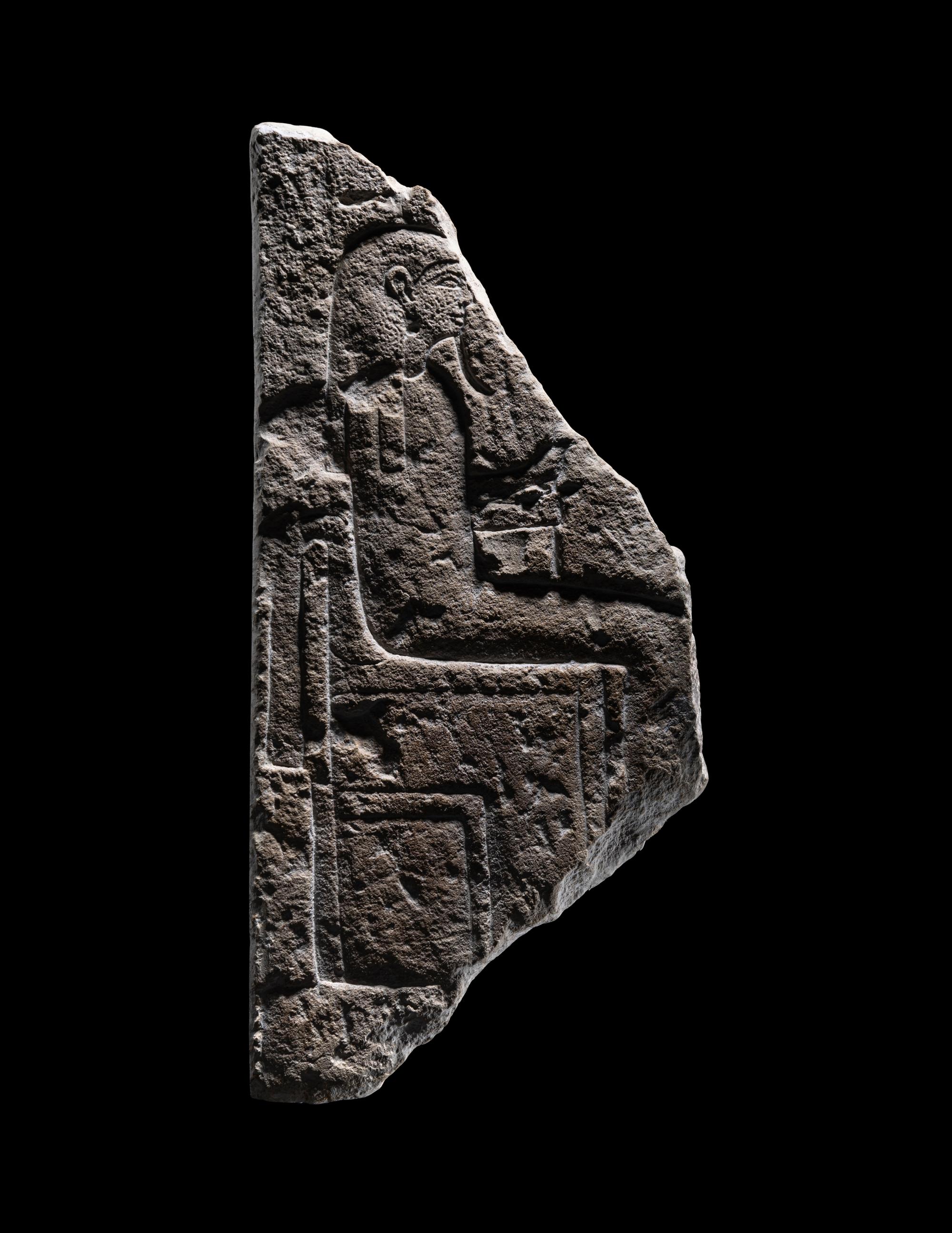 An Egyptian Limestone Stele Fragment with a Seated Pharaoh