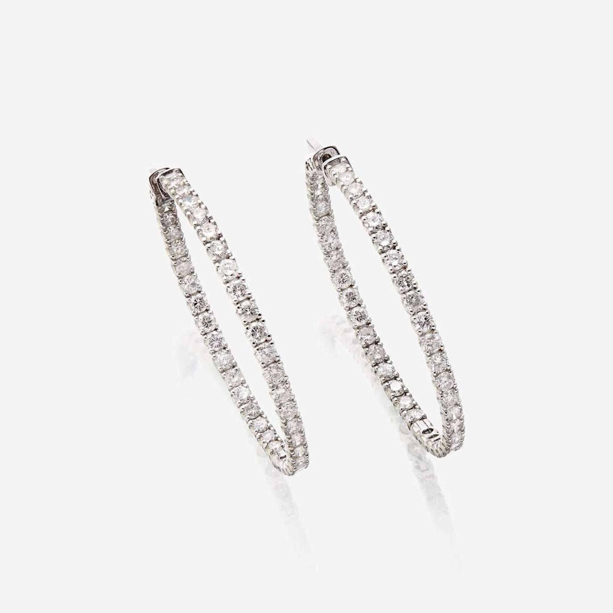 A pair of diamond and fourteen karat white gold earrings