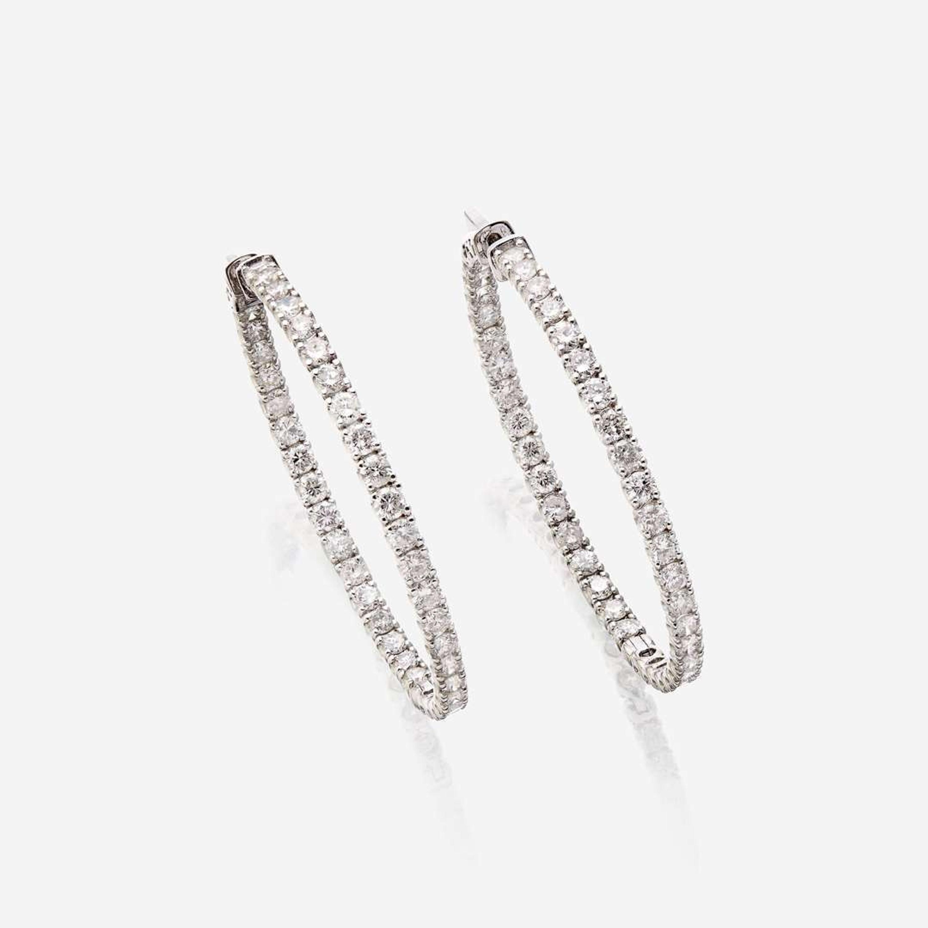 A pair of diamond and fourteen karat white gold earrings