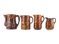 Seven Molded Yellowware Pitchers in Rockingham Glaze