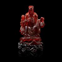 A Chinese carved amber figure of a sage and acolytes