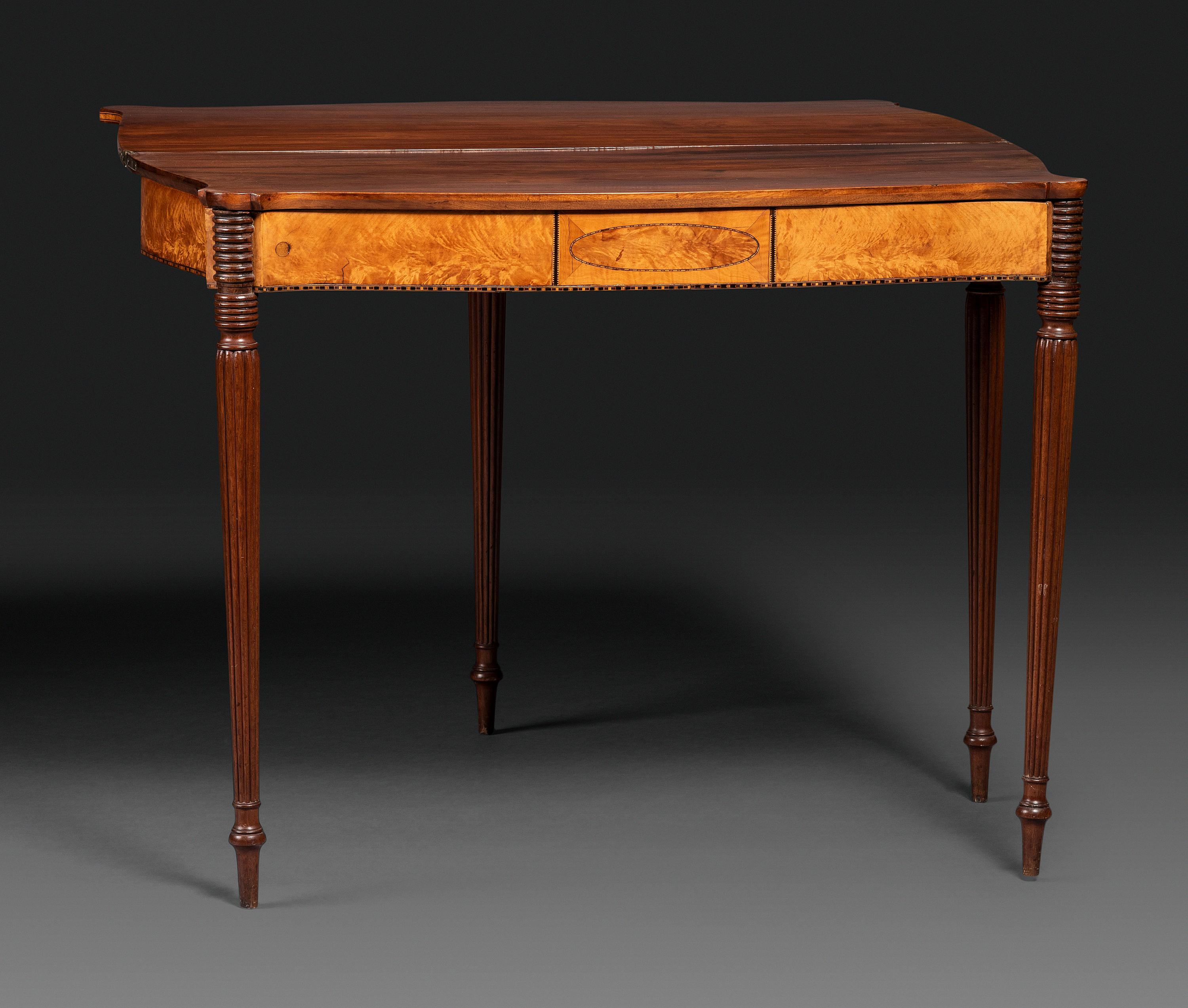 A Federal Birch Veneered and Inlaid Mahogany Serpentine-Top Games Table
