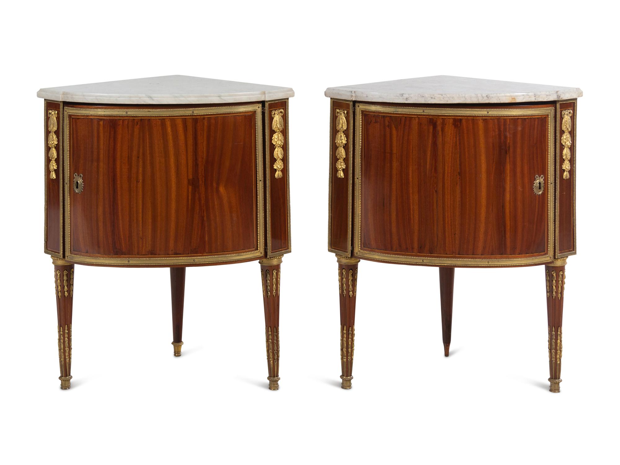 A Pair of Louis XVI Gilt Bronze Mounted Mahogany Marble-Top Encoignures by Charles Topino (French, 1742-1803)
