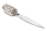 A Mexican Silver Paper Knife, Margot van Voorhies Carr, Taxco, Mid-20th Century, the handle worked with an Aztec deity, the reverse ins
