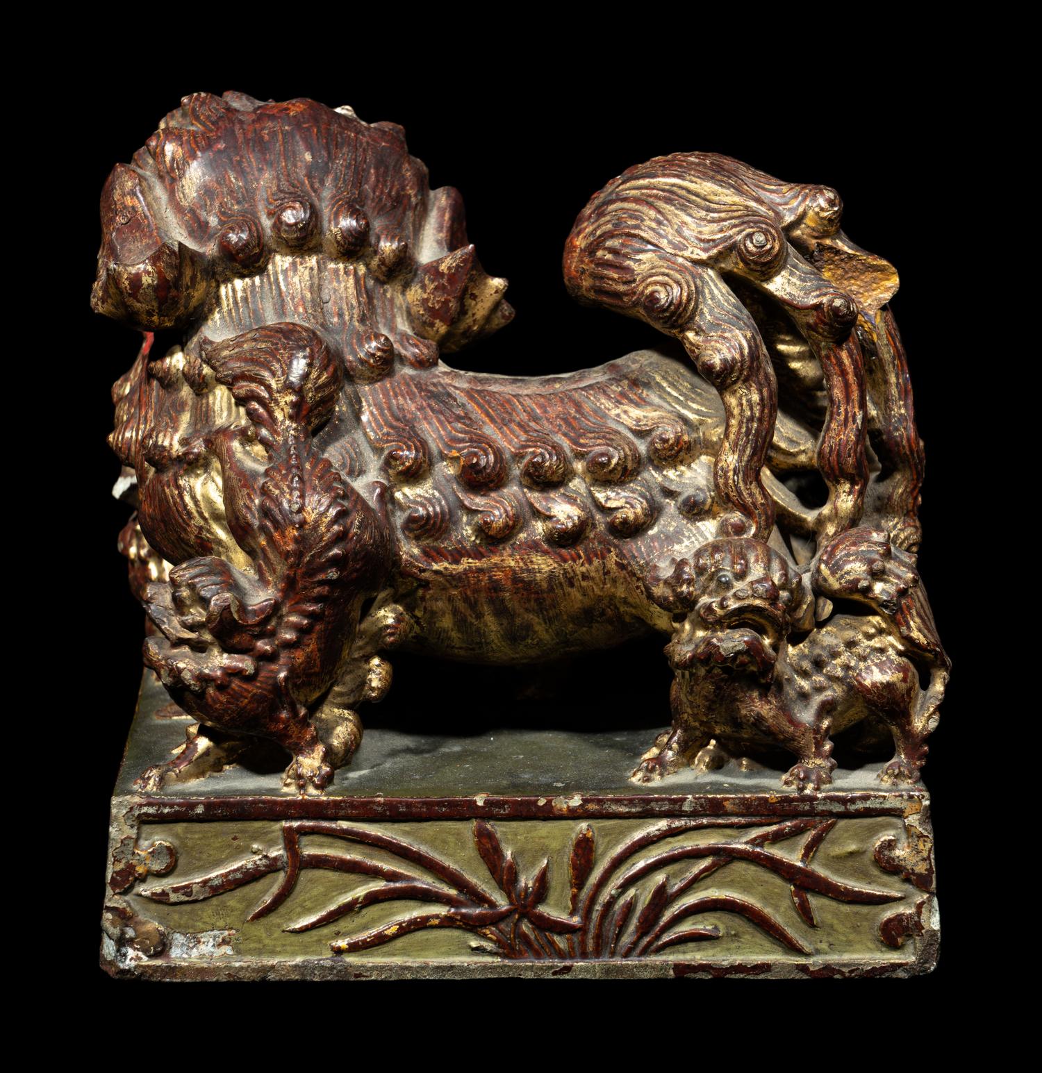 A Chinese Red and Gilt Lacquered Stone 'Buddhist Lion' Paperweight