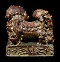A Chinese Red and Gilt Lacquered Stone 'Buddhist Lion' Paperweight
