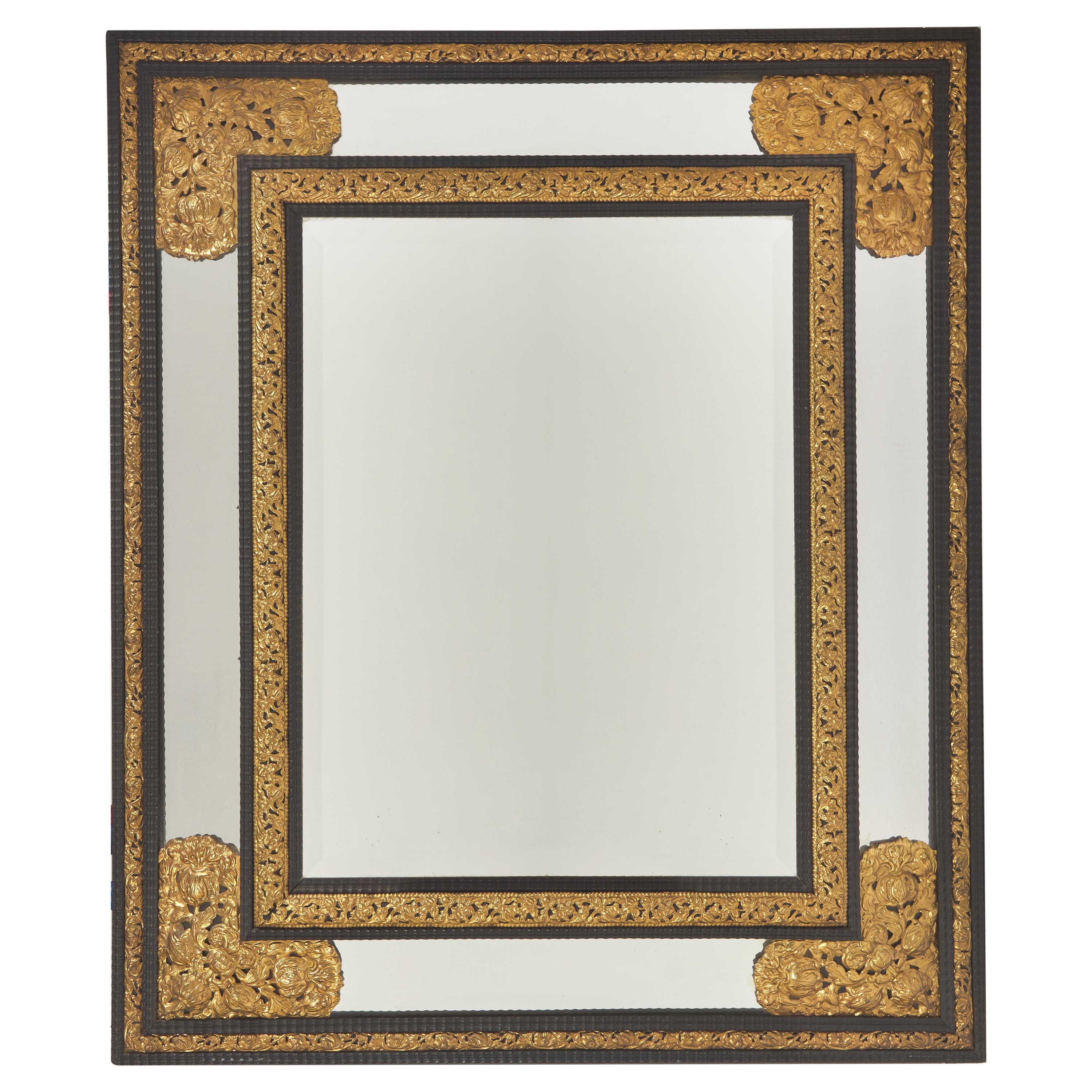 A Dutch Baroque Style Ebonized, Ripple Molded and Repoussé Gilt Brass Mounted Mirror
