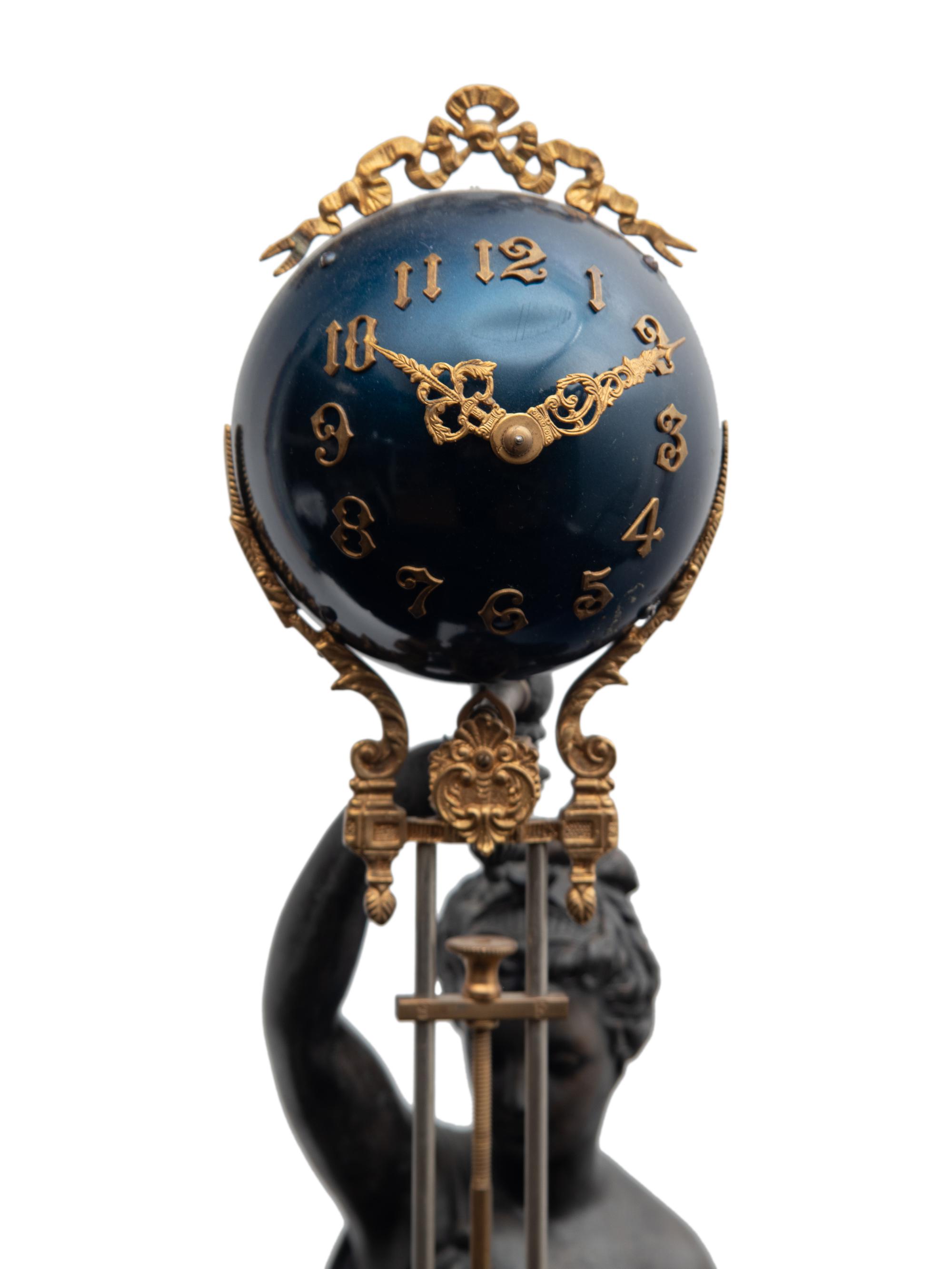 A Continental Cast Metal and Enameled Figural Pendulum Clock