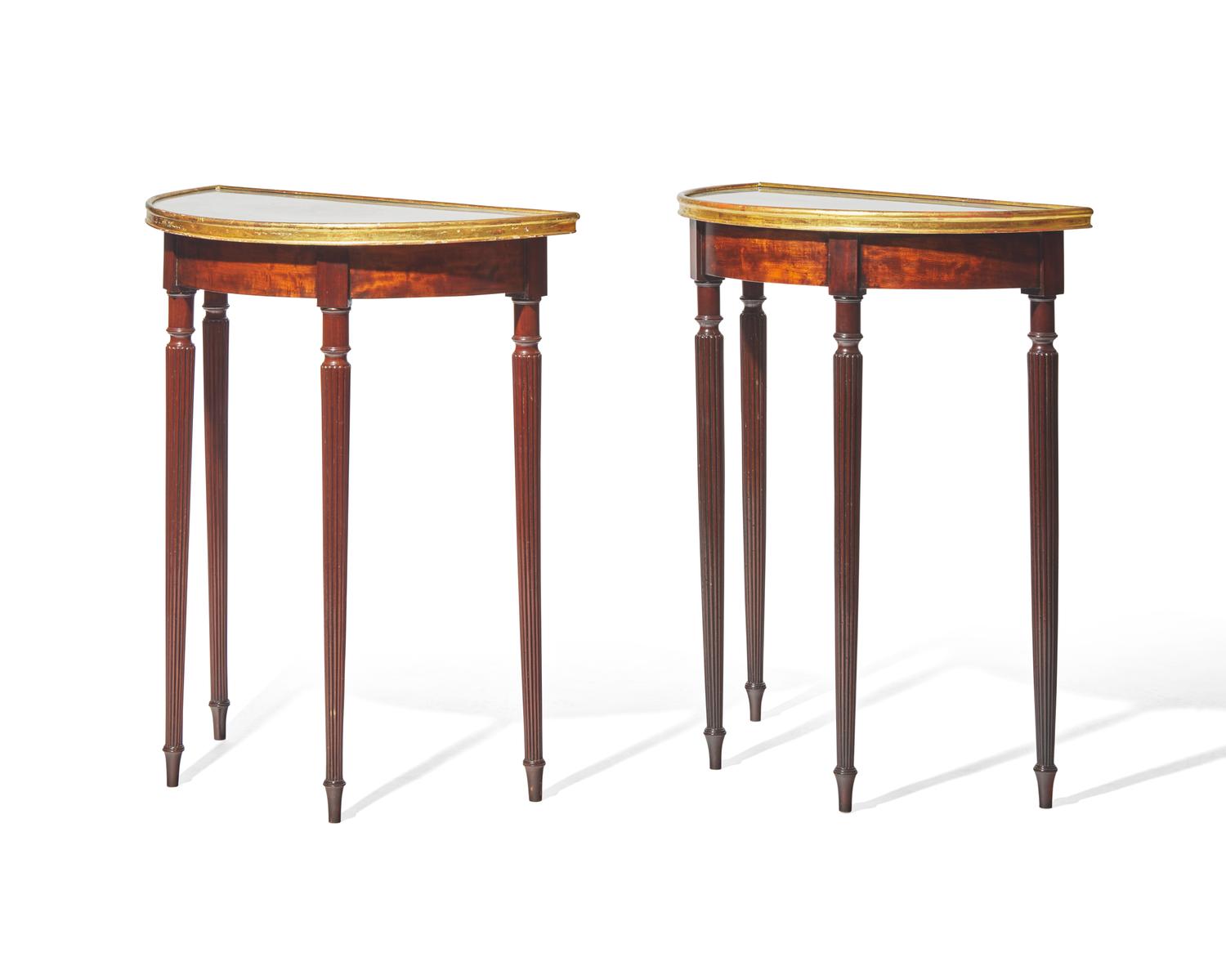 A pair of George III parcel-gilt mahogany demilune console tables with inset tops, circa 1810 and later