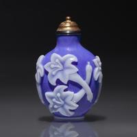 A Chinese White Overlaid Blue Glass Snuff Bottle, Qing Dynasty, 18th Century — 清中期 寶石藍地套白料萱花紋鼻煙壺