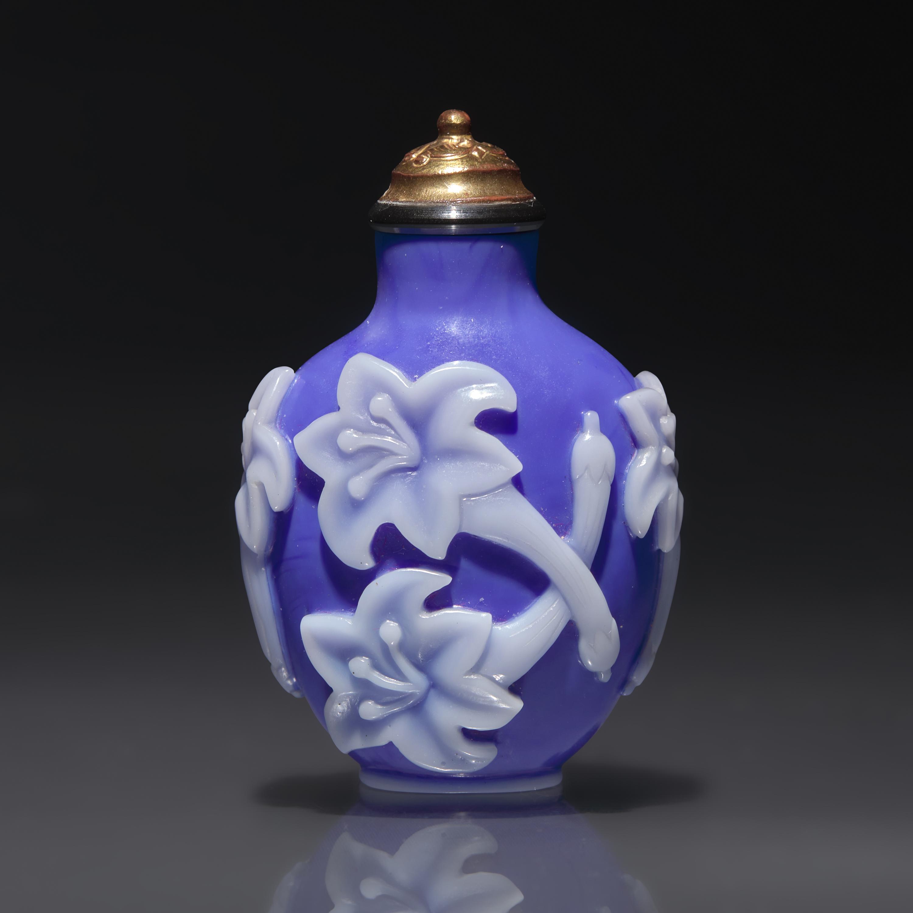 A Chinese White Overlaid Blue Glass Snuff Bottle, Qing Dynasty, 18th Century — 清中期 寶石藍地套白料萱花紋鼻煙壺