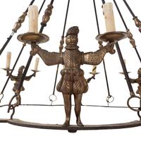 A Bronze and Iron Figural Sixteen-Light Chandelier