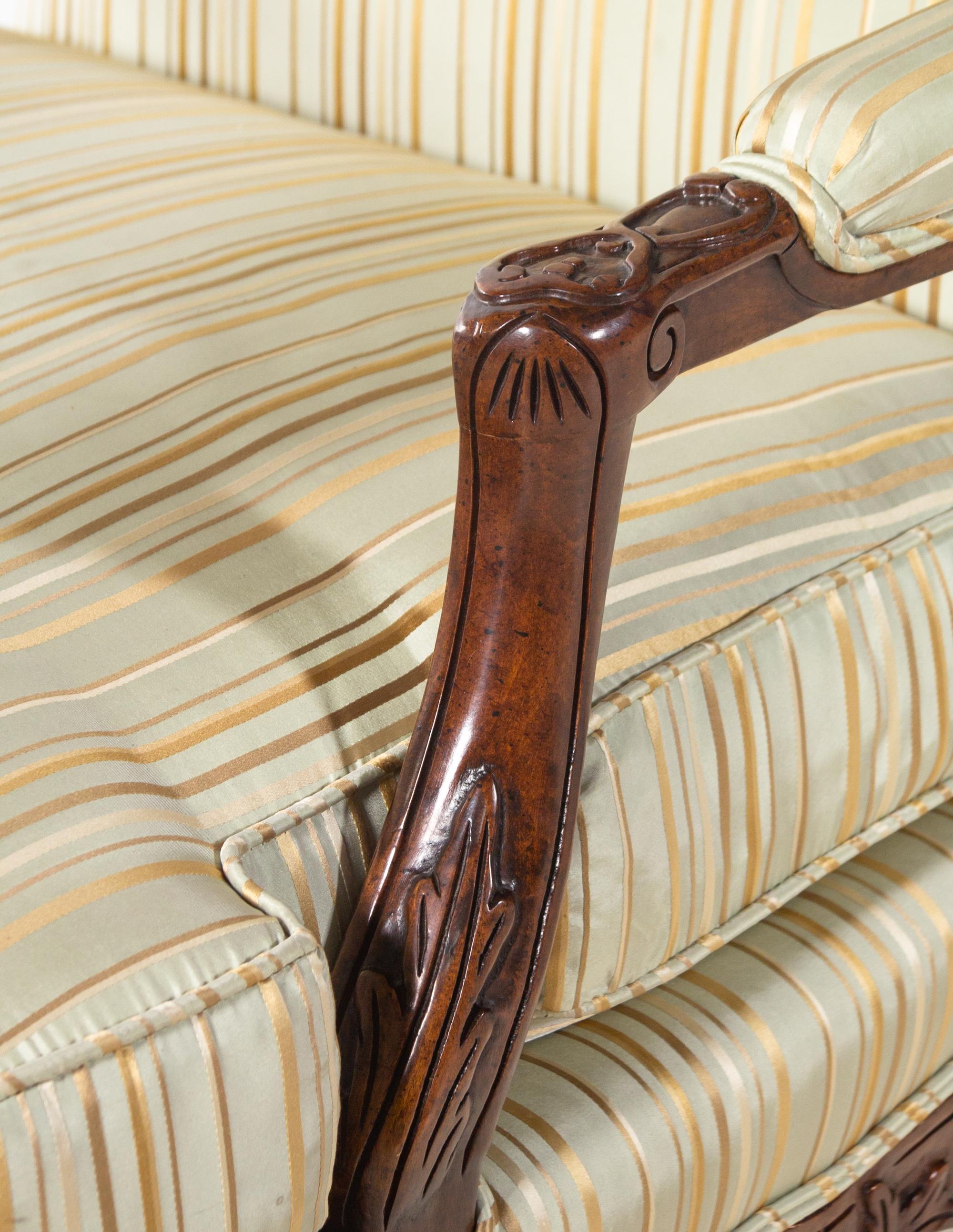 A Pair of Louis XV Style Carved Walnut Fauteuils