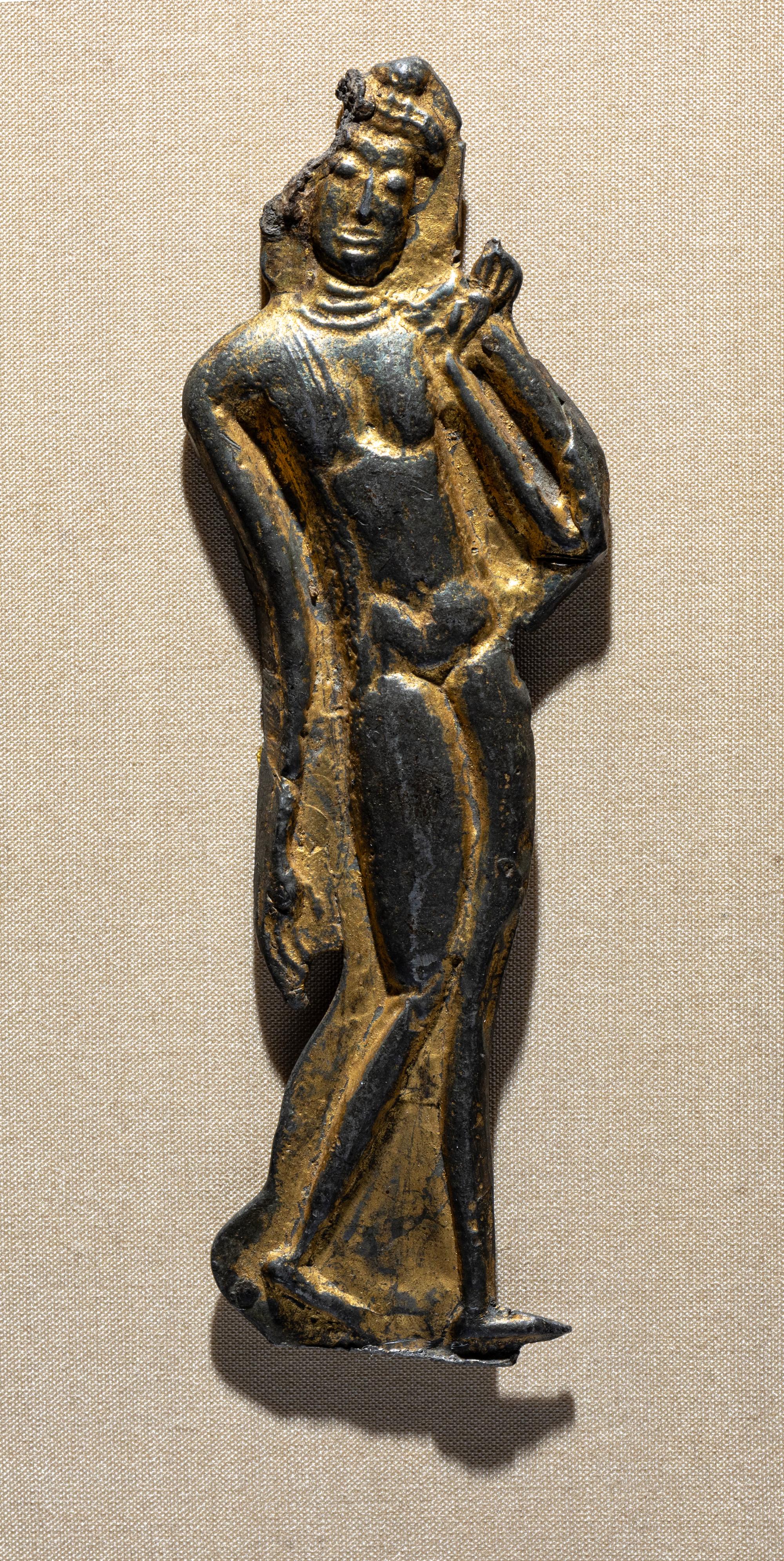 A Thai Parcel Gilt Bronze Relief of a Walking Buddha, 16th-17th Century