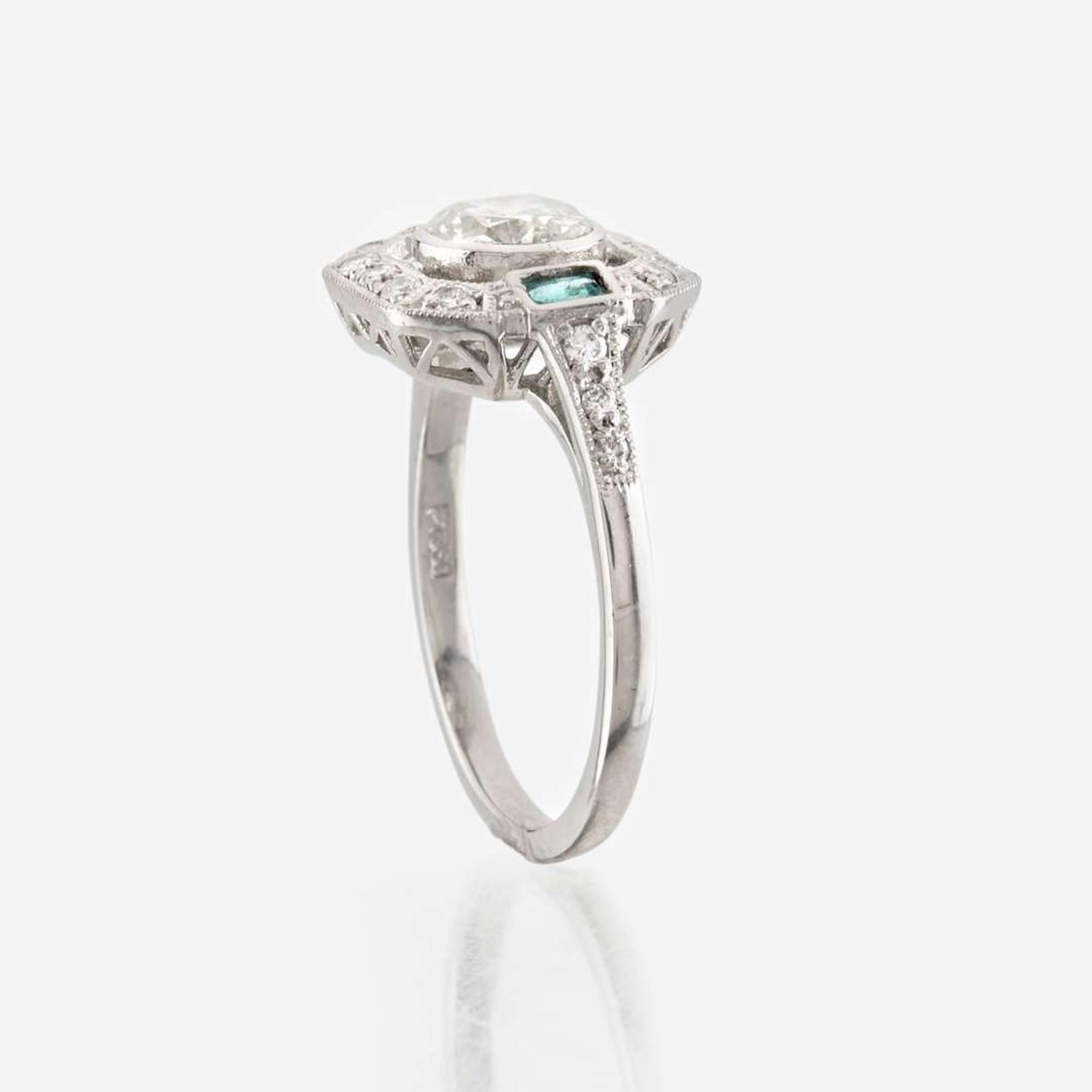 A diamond, emerald, and platinum ring