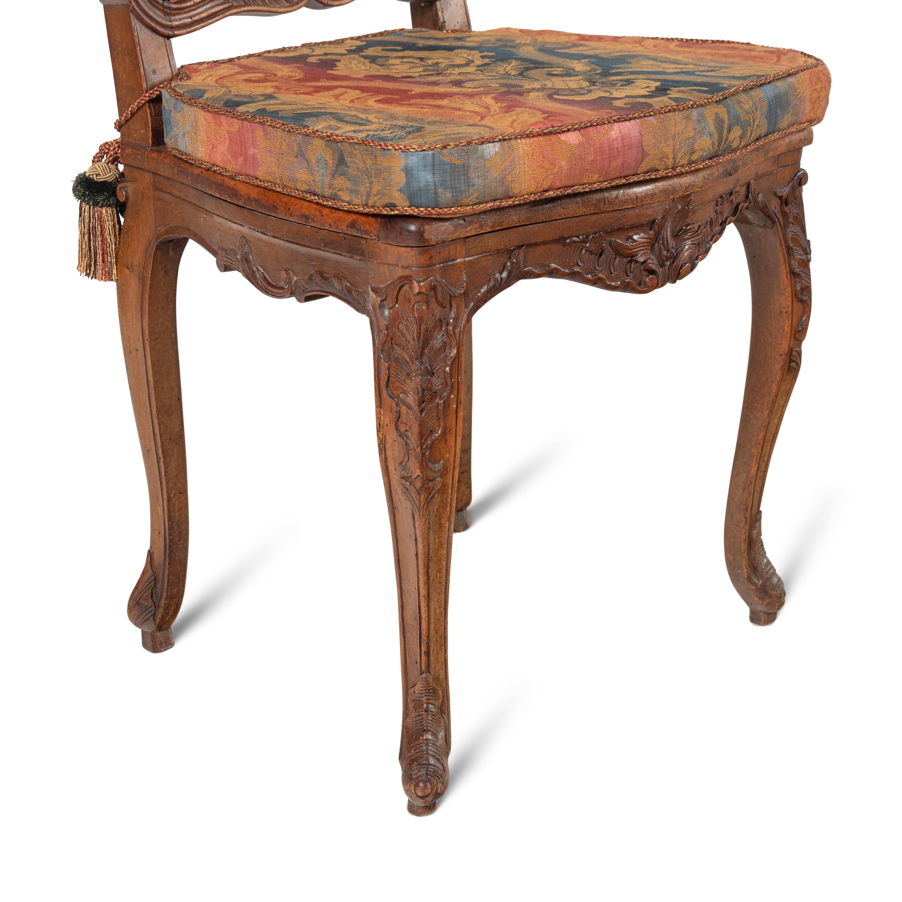 A Set of Eight French Carved Walnut and Caned Dining Chairs