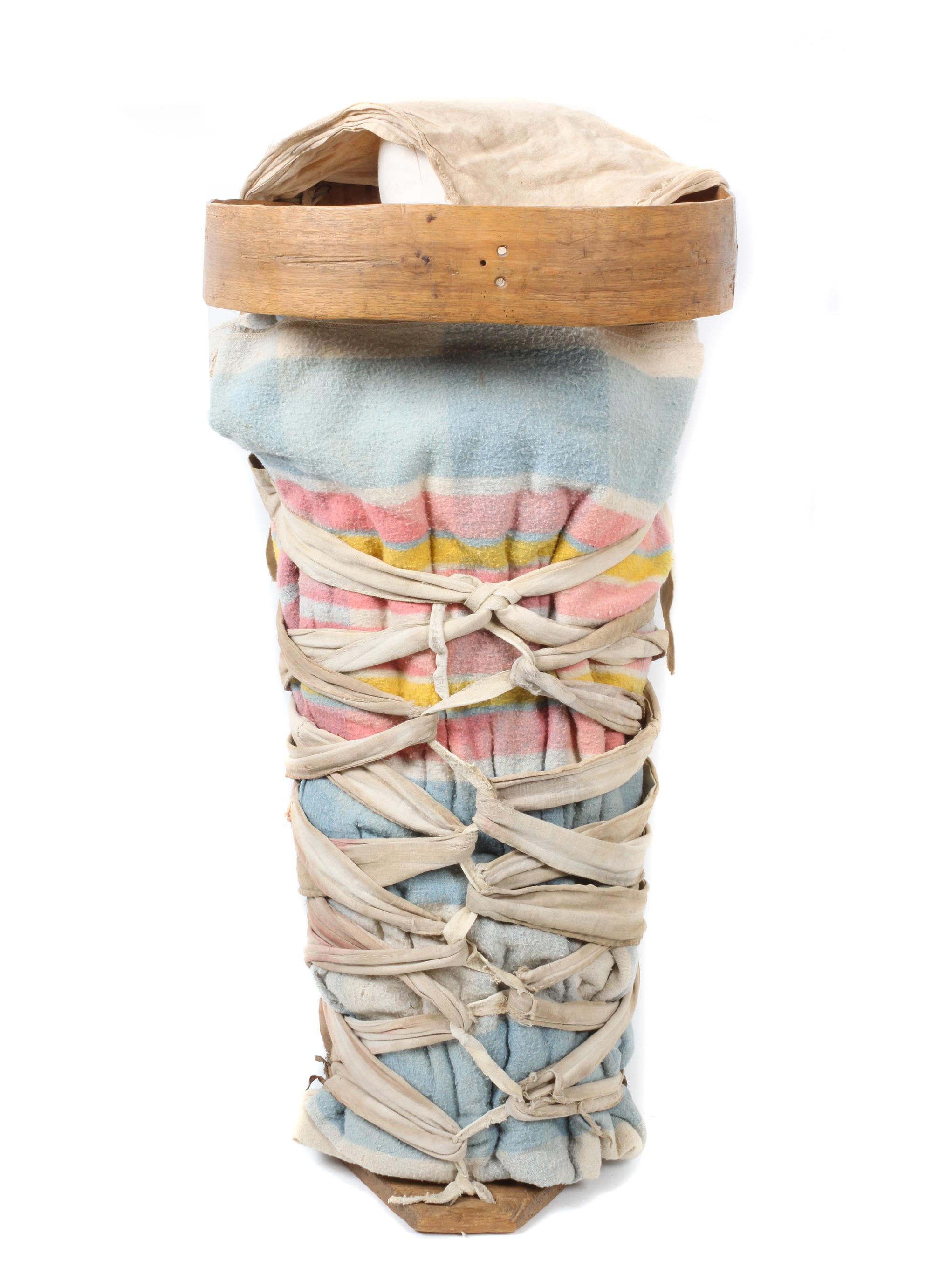 A Navajo Wood, Cloth, Leather Cradleboard Height 28 x width 13 1/4 inches.