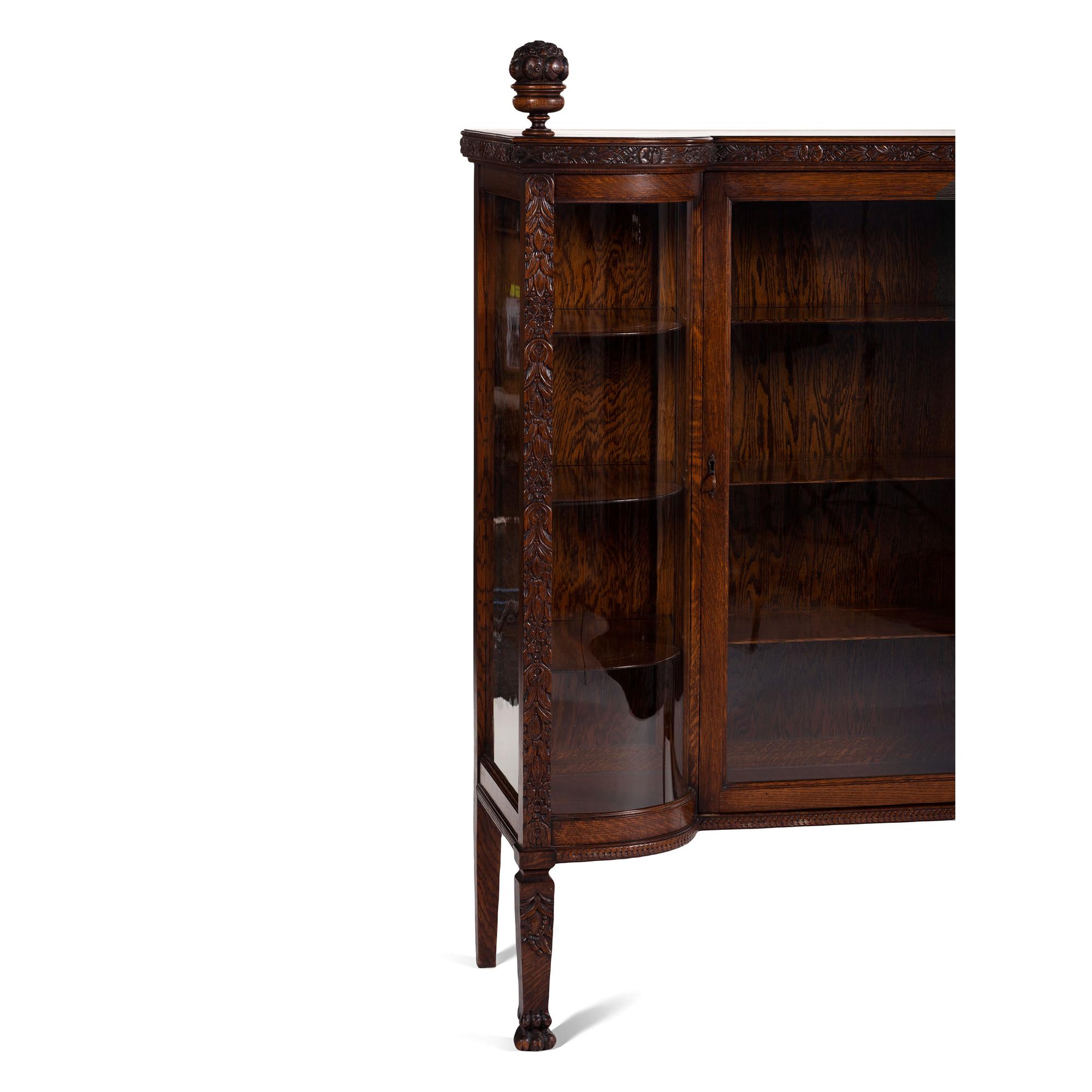 A Carved Oak Vitrine Cabinet and Open Bookshelf