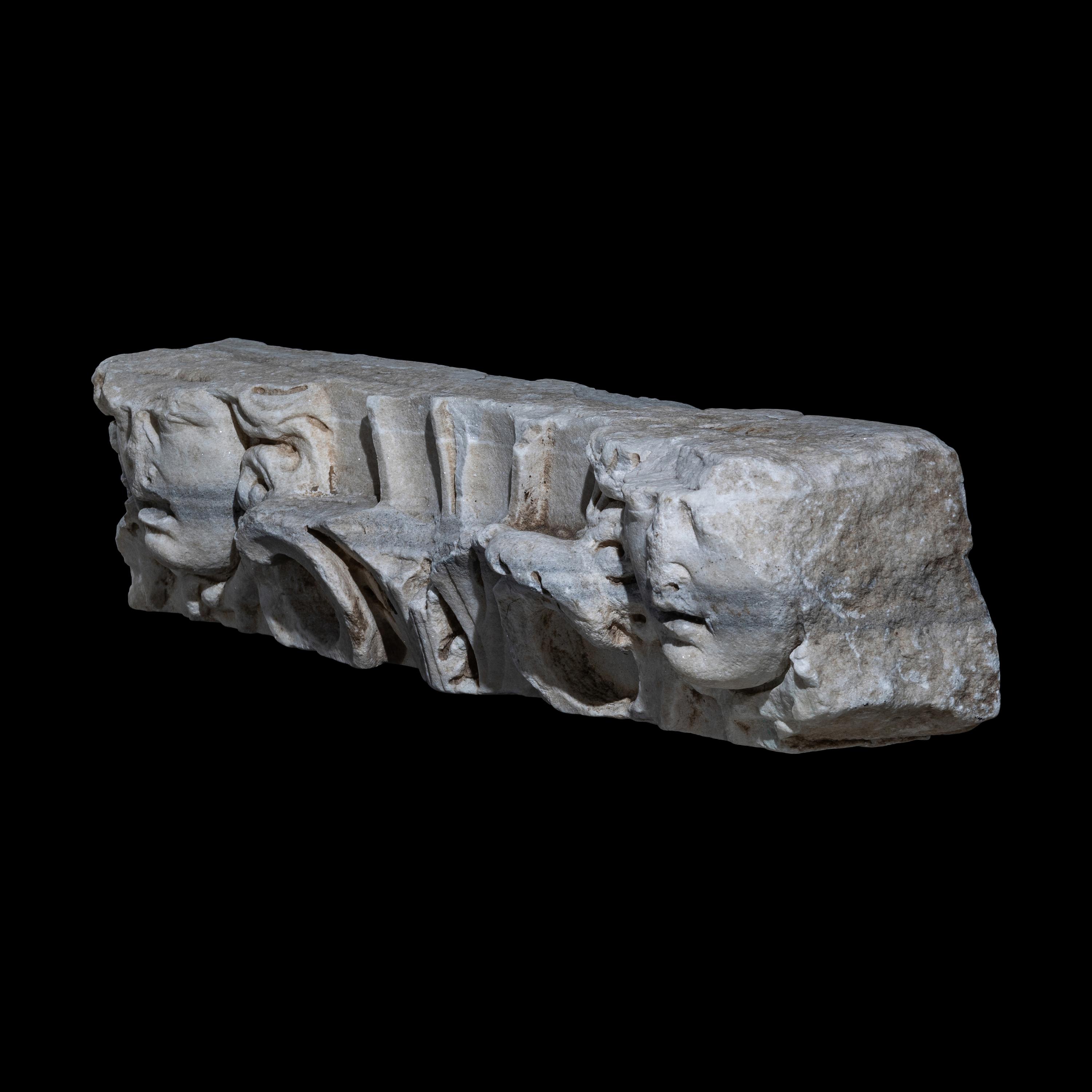 A Roman Marble Frieze Fragment with Heads of Medusa