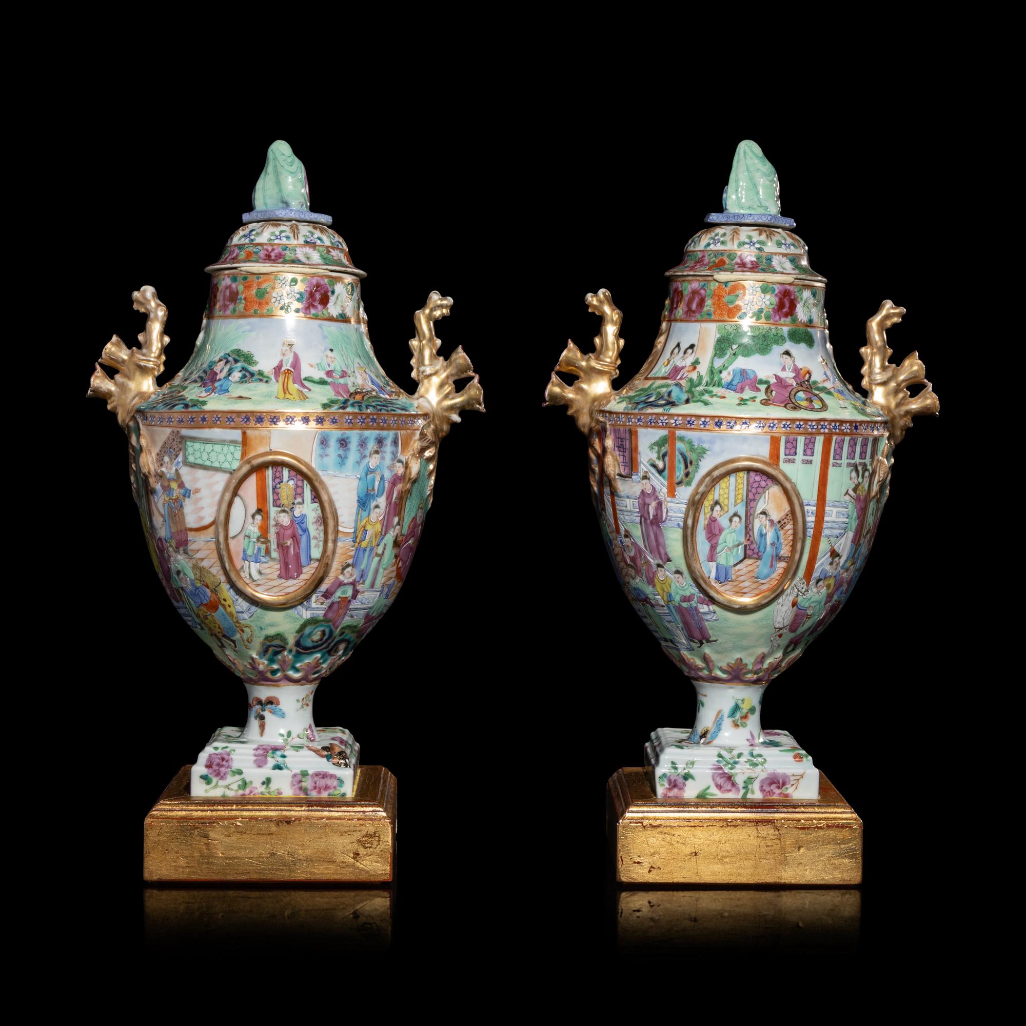 A Pair of Chinese Export Canton Famille Rose Porcelain Covered Urns, Early 19th Century — 清晚期 外銷廣彩人物故事圖獎杯形賞瓶一對