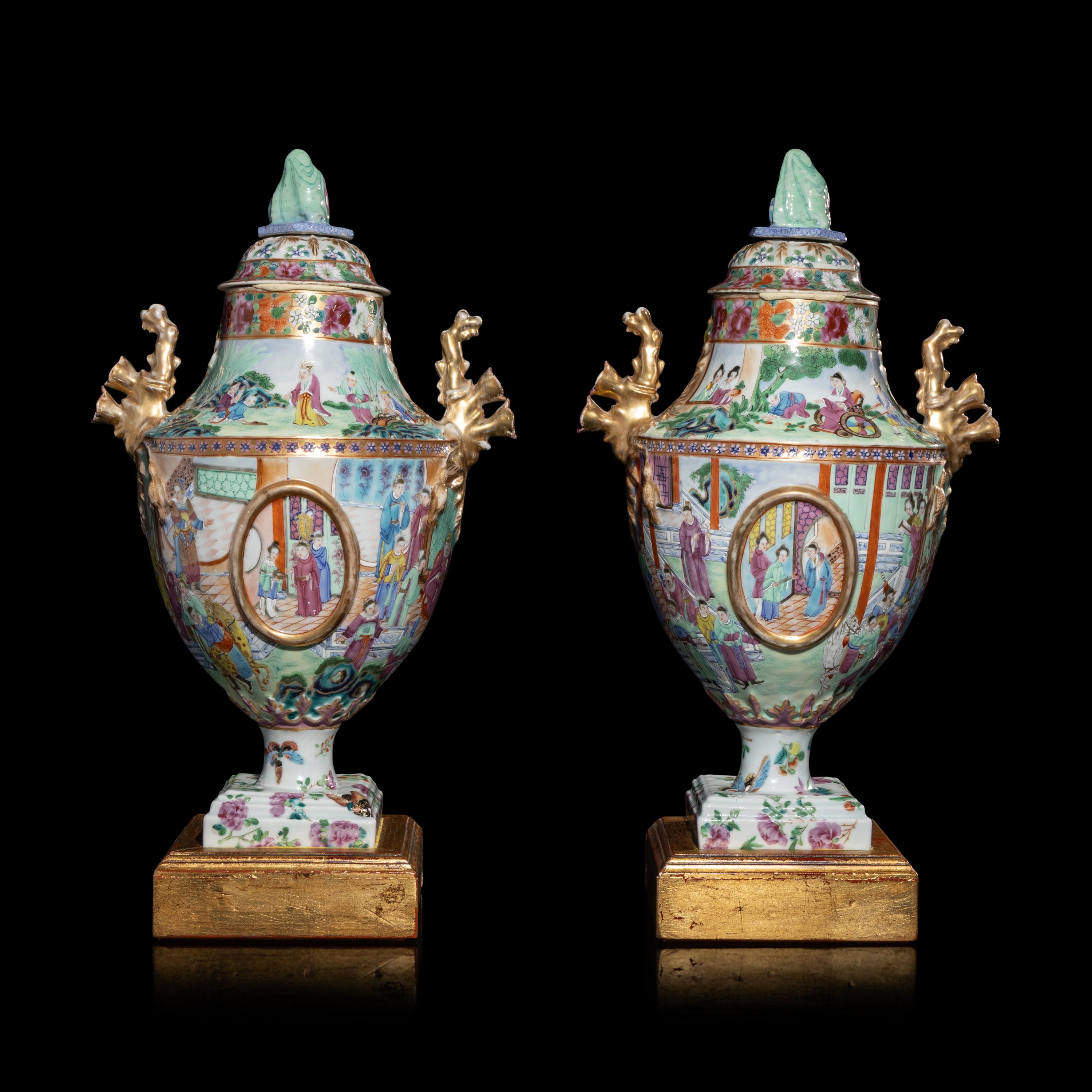 A Pair of Chinese Export Canton Famille Rose Porcelain Covered Urns, Early 19th Century — 清晚期 外銷廣彩人物故事圖獎杯形賞瓶一對