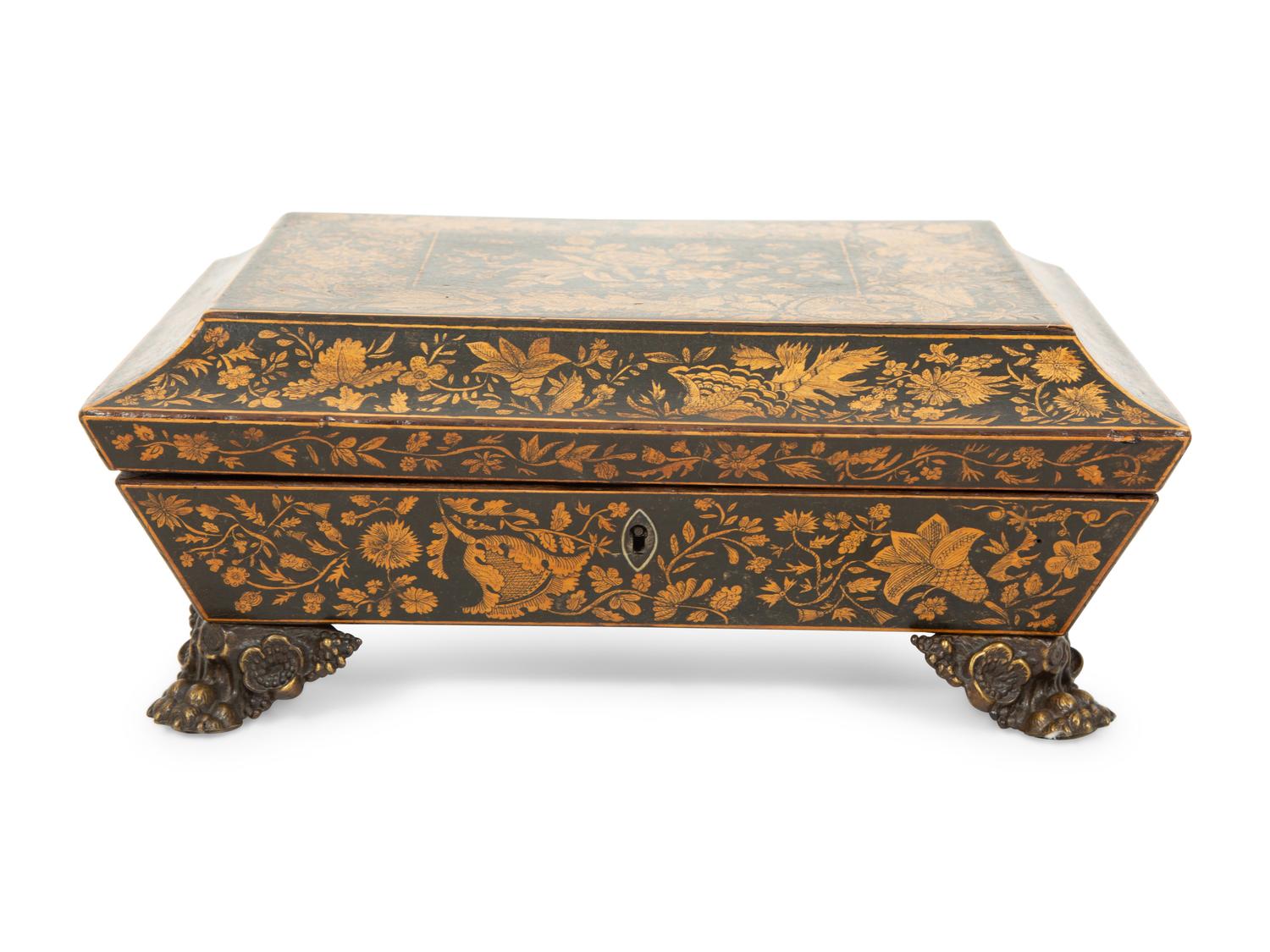 A Regency Black and Gilt Lacquer Box on Brass Paw Feet