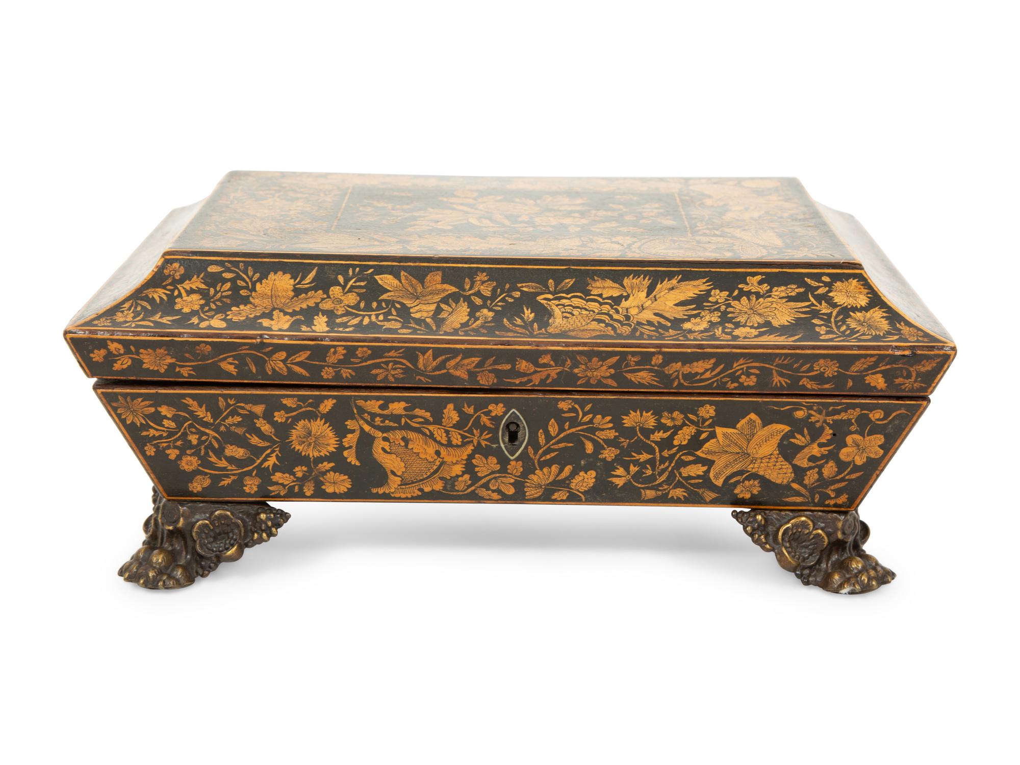 A Regency Black and Gilt Lacquer Box on Brass Paw Feet