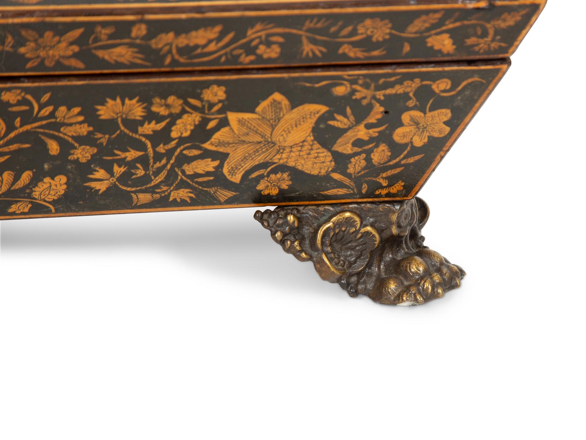 A Regency Black and Gilt Lacquer Box on Brass Paw Feet