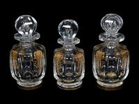 A Set of Three Baccarat Glass Decanters with Gilt Decoration