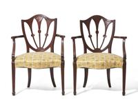 A pair of George III shield-back mahogany armchairs, late 18th / 19th century