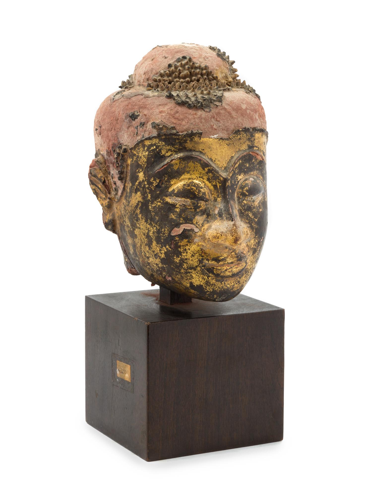 A Thai Parcel Gilt and Lacquered Terra Cotta Head of Buddha 16TH CENTURY OR EARLIER Height overall 12 3/8 inches. — 16TH CENTURY OR EARLIER