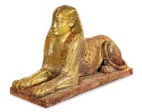 A Gold-Painted Cast Iron Model of a Sphinx Height 33 x width 19 x depth 59 inches. — 19TH CENTURY