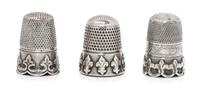A Group of Three Silver Thimbles, Various Makers, each having a knurled top and body above a band worked to show fleurs-de-lis.