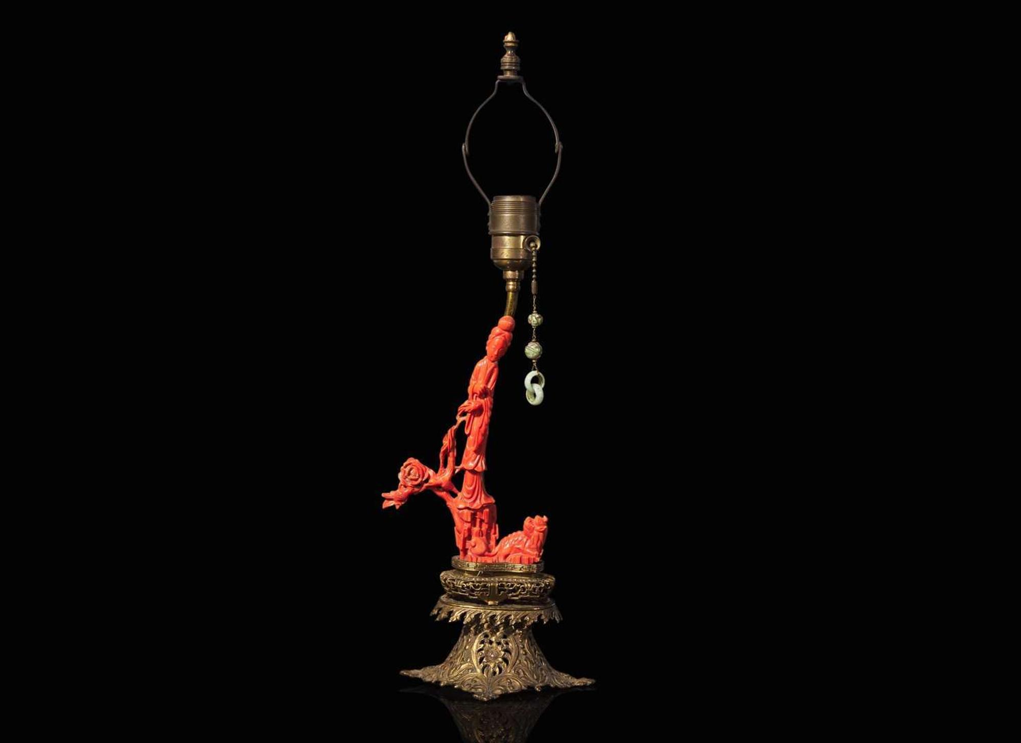 A Chinese carved coral figure mounted on a gilt-metal lamp base 珊瑚雕人物嵌銅鎏金燈座