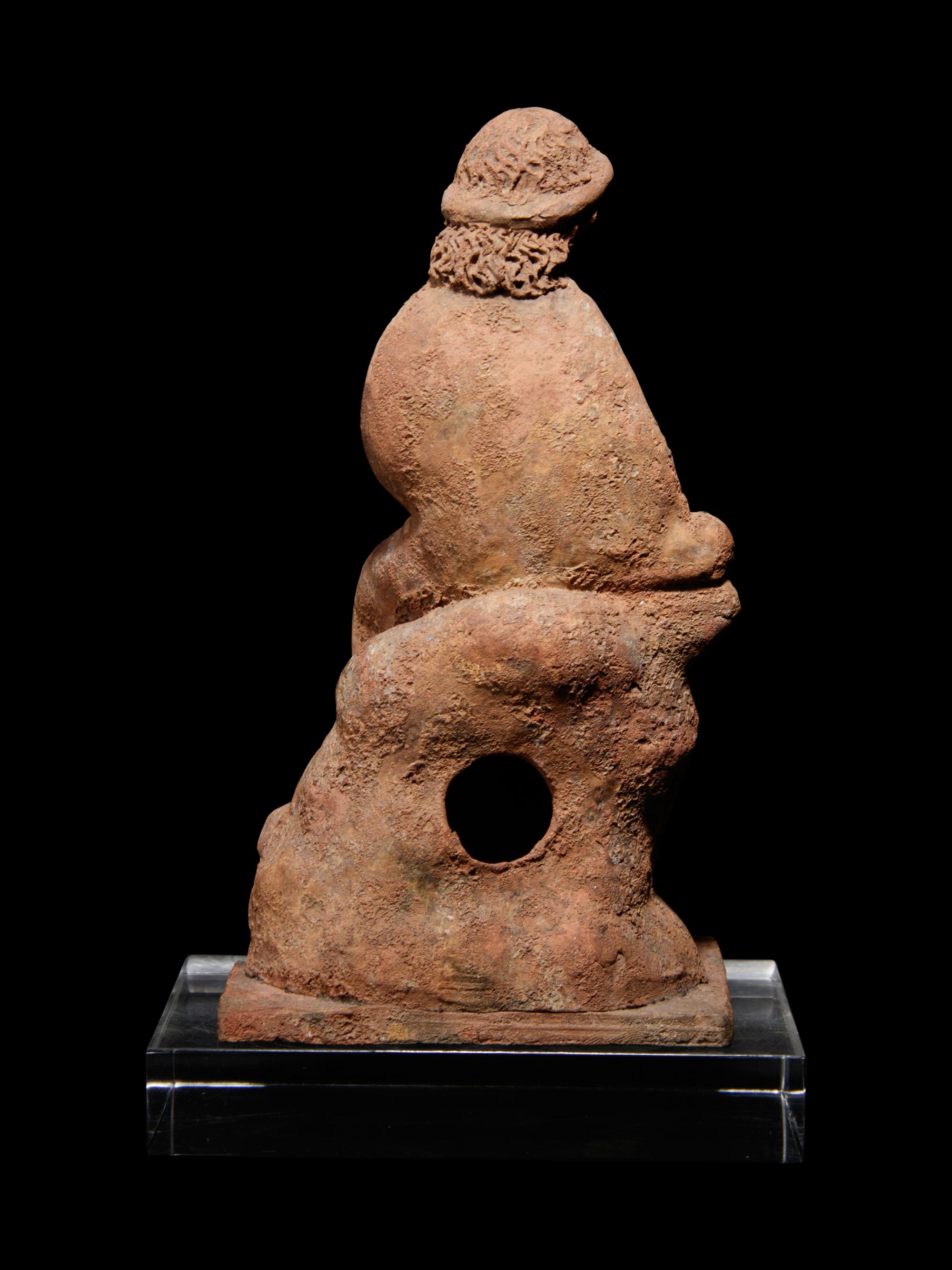 A Greek Terracotta Seated Scholar Holding a Wine Jug