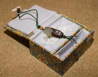 A Celadon and Russet Jade Bead. Length 1 1/2 inches.