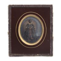 An Ambrotype of A Black Doll in a Plaid Dress With Painted and Gilt Highlights