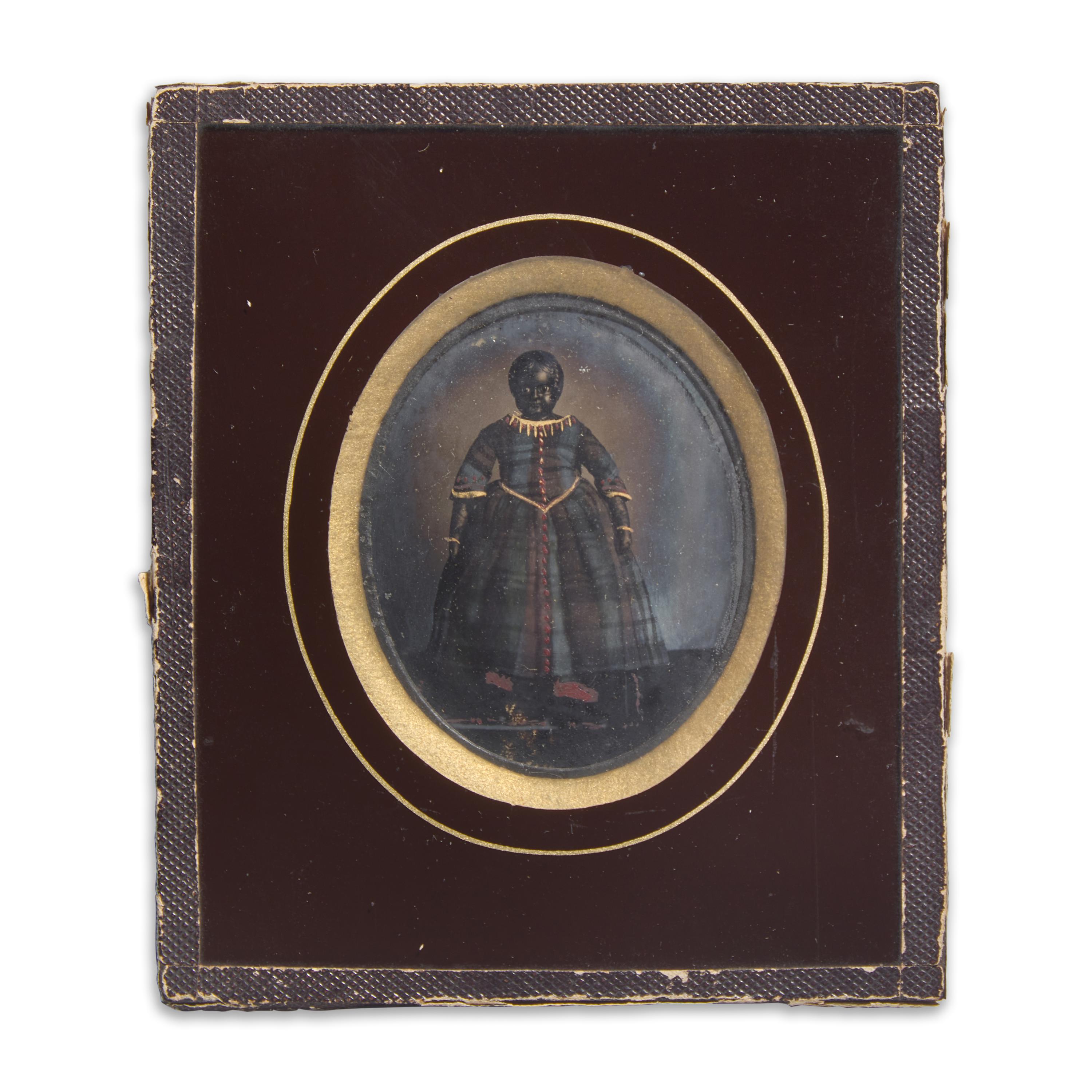 An Ambrotype of A Black Doll in a Plaid Dress With Painted and Gilt Highlights