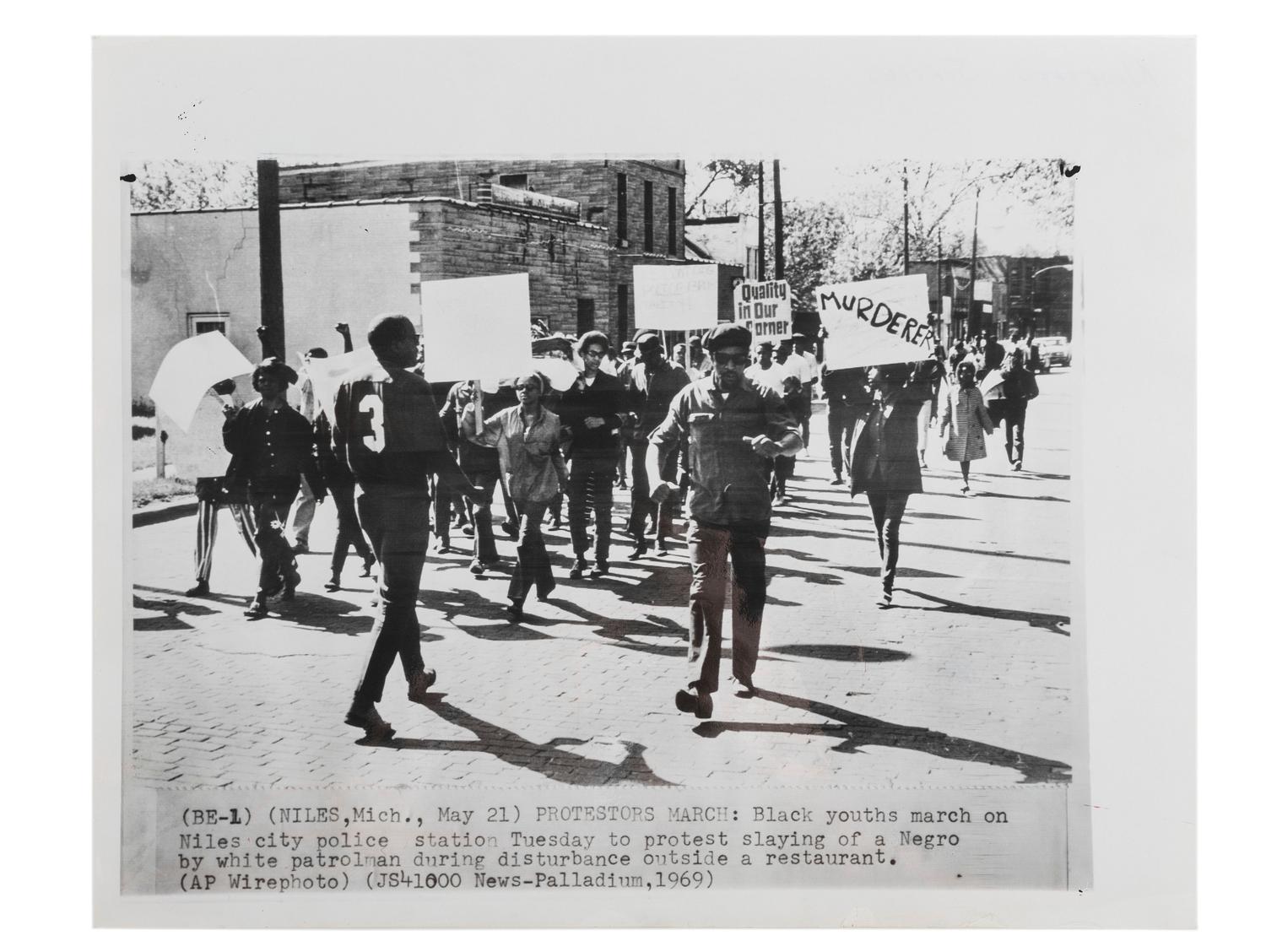 [CIVIL RIGHTS]. Press photograph of African American youths marching on the Niles, MI, police station to protest the slaying of an African American by a white patrolman during a disturbance. Niles, MI, 27 May 1969.