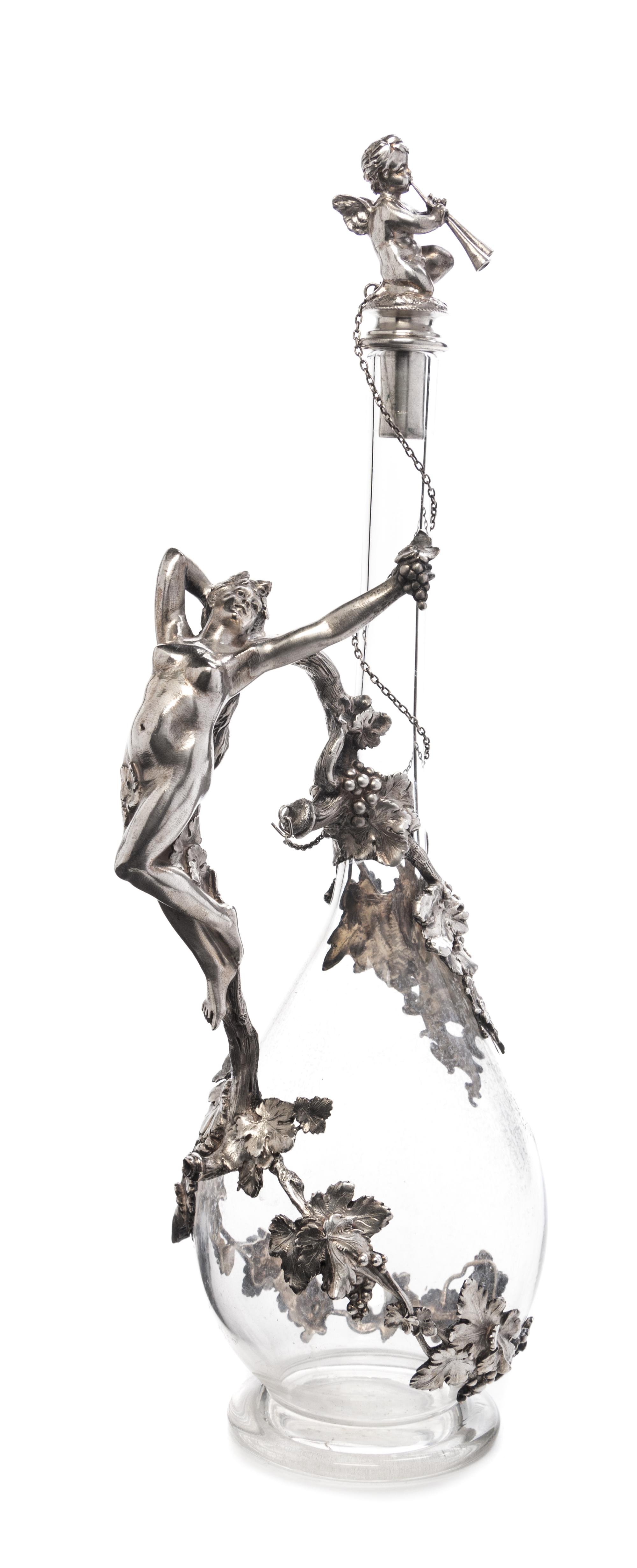 A German Silver Mounted Cut Glass Decanter, Bruckmann & Sohne, Heilbronn, Circa 1910, having a figural stopper in the form of winged pu