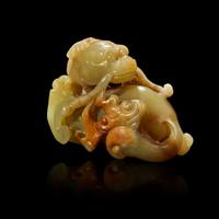 A Chinese small celadon, beige and russet jade figure of a mythical beast Qing Dynasty, 18th Century or earlier