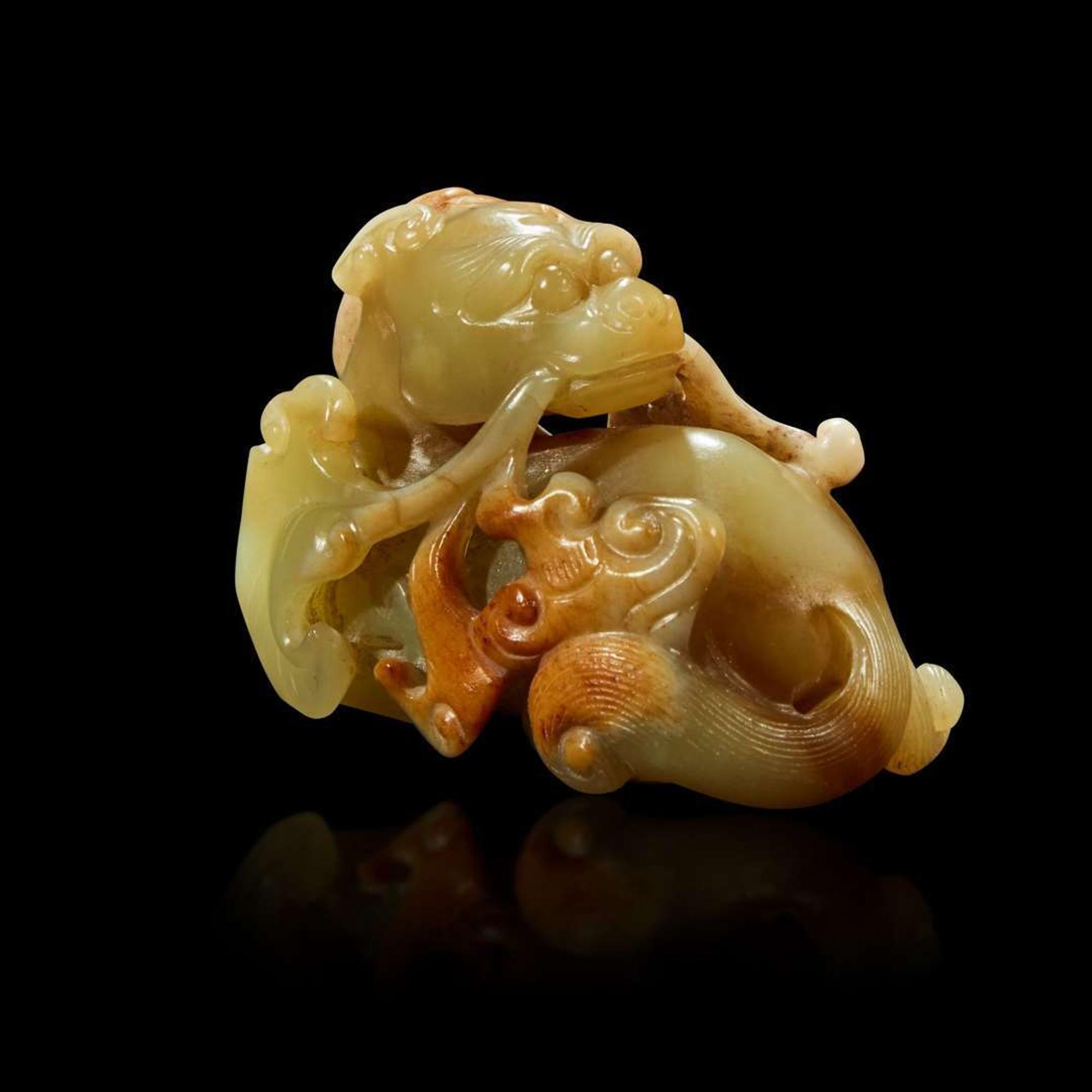 A Chinese small celadon, beige and russet jade figure of a mythical beast Qing Dynasty, 18th Century or earlier