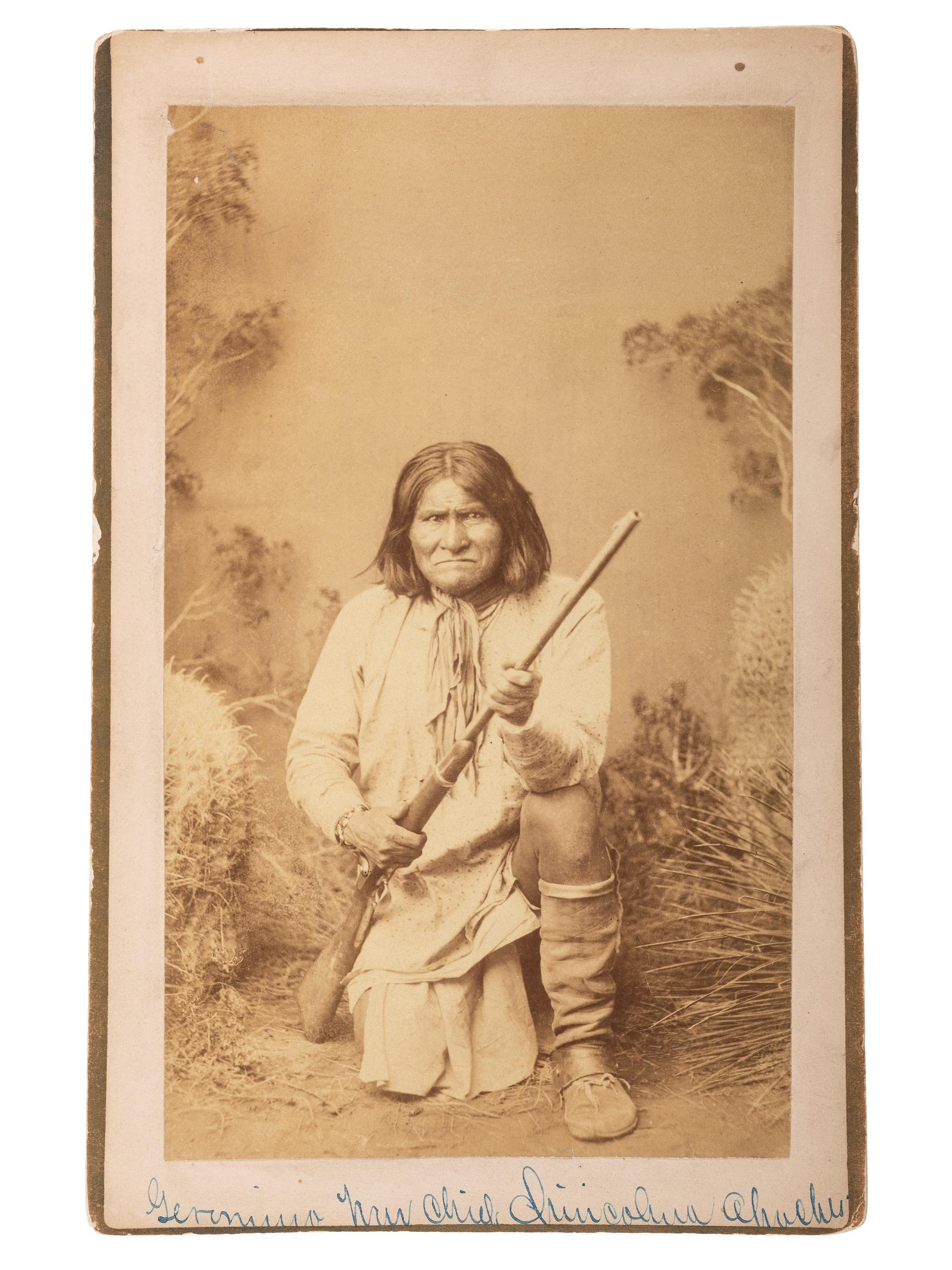 [NATIVE AMERICANS]. RANDALL, A. Frank, photographer. Boudoir card of Geronimo kneeling, holding an 1873 Springfield carbine rifle. Wilcox, Arizona Territory: 1885.
