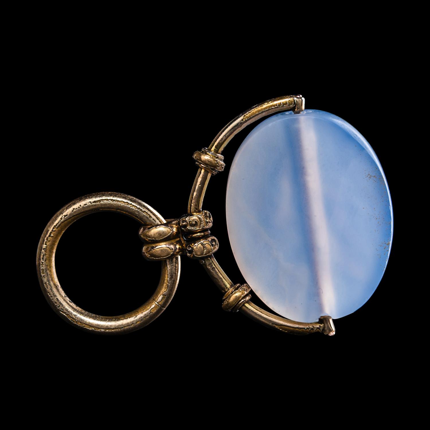 A Greek Blue Chalcedony Intaglio with a Satyr Holding a Herm — Set in a gold pendant